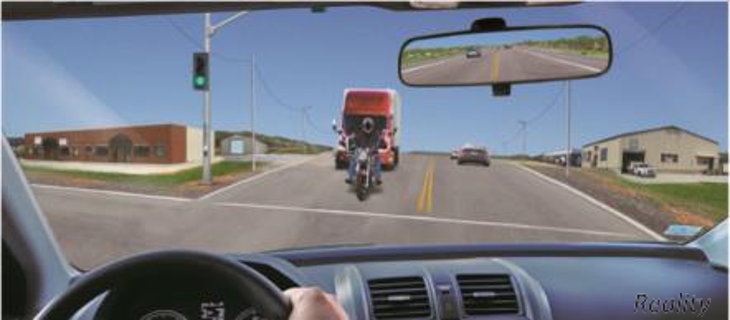 Image of a motorcycle at an intersection through the lens of another vehicle